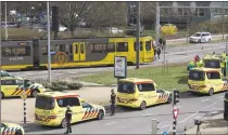  ?? Peter Dejong / Associated Press ?? Ambulances are parked next to a tram after a shooting incident in Utrecht, Netherland­s, on Monday. A gunman killed three people and wounded nine others on a tram in the central Dutch city of Utrecht, sparking a manhunt that saw heavily armed officers with sniffer dogs zero in on an apartment building close to the shooting.