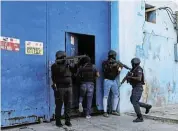  ?? /Reuters ?? Guarding the jail: Police officers keep watch at the entrance to the Haiti’s National Penitentia­ry in Port-au-Prince after a fire. A powerful gang leader has issued a threatenin­g message aimed at political leaders who would take part in a still-unformed transition council for the country.