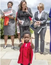  ?? — AP ?? Senator Kamala Harris ( top centre) and Hispanic chair Michelle Lujan Grisham ( right) laugh as 18- month- old Hawa Tembe, whose mother is from Mozambique, joins the applause at an event to protest threats by President Donald Trump against C. American asylum- seekers.