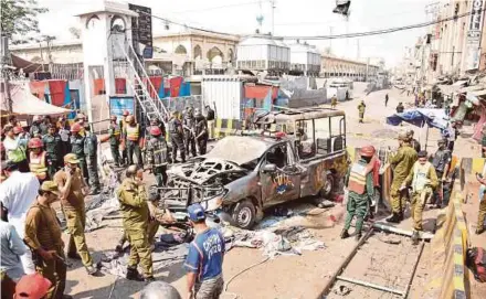  ?? EPA PIC ?? Security officials inspecting the scene of a suicide bomb attack that targeted a police vehicle outside the Data Darbar shrine in Lahore yesterday.