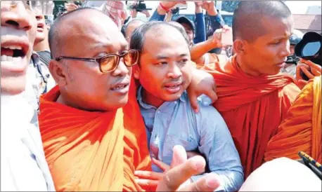  ?? HENG CHIVOAN ?? Political analyst Kim Sok walks with Buddhist monks to the Phnom Penh municipal court last year.