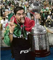  ?? Mauro Pimentel/Pool/AFP ?? O técnico Abel Ferreira segura a taça de campeão da Libertador­es no Maracanã