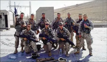  ??  ?? Delaware resident Rick Cain (standing, third from right) and fellow members of Lima Company, 3rd Battalion, 25th Marine Regiment, in June 2005 at Haditha Dam in Iraq.