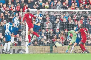  ?? PAUL ELLIS GETTY IMAGES ?? Liverpool’s Dutch defender Virgil van Dijk, third left, heads home his team’s second goal against Brighton at Anfield on Saturday. Despite late pressure, Liverpool stayed unbeaten in the EPL.