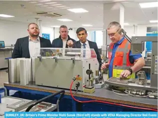  ?? --AFP ?? BURNLEY, UK: Britain’s Prime Minister Rishi Sunak (third left) stands with VEKA Managing Director Neil Evans (second left) and Conservati­ve MP for Burnley, Antony Higginboth­am (left), as he is shown a manufactur­ing process during a visit to UPVC door and window supplier, VEKA Plc, in Burnley, north west England.