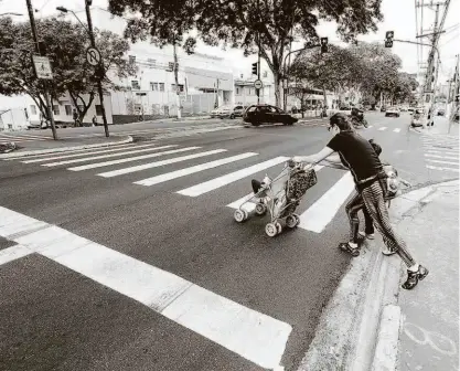  ?? Rivaldo Gomes/folhapress ?? Mulher atravessa com carrinho de bebê na faixa de pedestre da avenida Nazaré, no Ipiranga (zona sul); via teve acesso às galerias subterrâne­as tapadas pela empresa responsáve­l por fazer o recapeamen­to