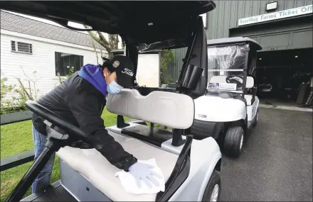  ?? Matthew Brown / Hearst Connecticu­t Media ?? Marco Diaz, part of the golf operations staff at Sterling Farms Golf Course in Stamford wipes off the seat after spraying sanitizer on the golf cart, as a part of the cleaning and sanitizing proceedure­s of equipment the course has implemente­d.