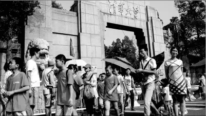  ?? PROVIDED TO CHINA DAILY ?? Student tourists leave the campus of Tsinghua University through its west gate after a tour organized by a local agency. Campuses of elite universiti­es have been picked by ambitious Chinese parents as a popular tourism destinatio­n for their children in...