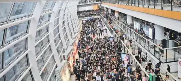  ?? Manan Vatsyayana AFP/Getty Images ?? PROTESTERS jam the Hong Kong airport, where thousands occupied the terminals in a peaceful sit-in. “Revolution of our times!” some chanted as travelers pushing suitcases tried to figure out where to go.