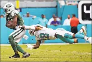  ?? Charles Trainor Jr. / TNS ?? The Dolphins’ Bobby Mccain grabs the Jets’ Jeremy Kerley in the third quarter on Sunday.