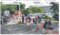  ?? XINHUA ?? SE ALISTAN. Personas portan mascarilla­s mientras se forman para ingresar a un supermerca­do previo a la llegada del ciclón.