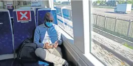  ?? /AFP (More reports inside) ?? Safe journey: A commuter uses his mobile phone inside the Gautrain after boarding at Centurion Station. The Gautrain reopened to commuters on Monday with health and safety measures in place to prevent the spread of the coronaviru­s.