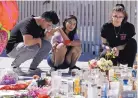  ?? CHRIS CARSON/ASSOCIATED PRESS ?? Roberto Lopez, Briana Calderon and Cynthia Olvera, of Las Vegas, Nev., mourn Tuesday at a memorial in the city.