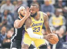  ?? — AFP photo ?? Lamar Stevens (left) of the Memphis Grizzlies guards LeBron James of the Los Angeles Lakers.