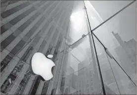  ?? AP-Mark Lennihan, File ?? The sun is reflected on Apple’s Fifth Avenue store in New York. Apple is the first U.S. company to boast a market value of $2 trillion, just two years after it became the first to reach $1 trillion. Apple shares have gained nearly 60% this year as the company overcame the shutdown of factories in China that produce the iPhone and the closure of its retail sales amid the coronaviru­s pandemic.