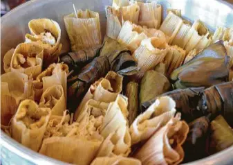  ?? Paula Murphy ?? Hugo’s cochinita pibil, chicken in mole poblano, and mushroom and pipian tamales are $24 a dozen.