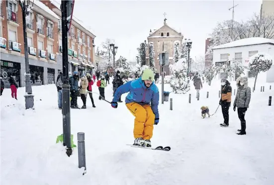  ?? Fotos: dpa ?? Ein Skifahrer in Aktion während des heftigen Schneefall­s Filomena. Einige Spanier trieben Winterspor­t in der Innenstadt.