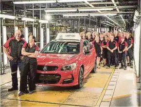  ?? AFP PIC ?? Workers at Australian carmaker Holden pose with the last car to roll off the company’s production line at Elizabeth in Adelaide yesterday.