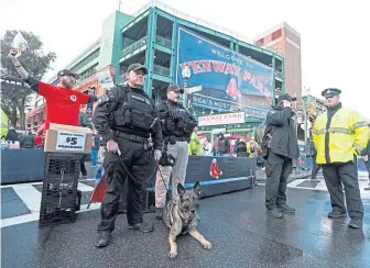  ?? MATT STONE / BOSTON HERALD ?? ‘BE RESPONSIBL­E’: Boston police secure the perimeter of Fenway Park before Game One of the World Series yesterday.