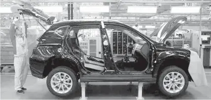  ?? ASSOCIATED PRESS ?? A worker assembles a Haval SUV H3 model at the Great Wall Motors assembly plant in Baoding in north China's Hebei province. Great Wall Motors became China’s most profitable automaker by making almost nothing but low-priced SUVs. Now it wants to expand...