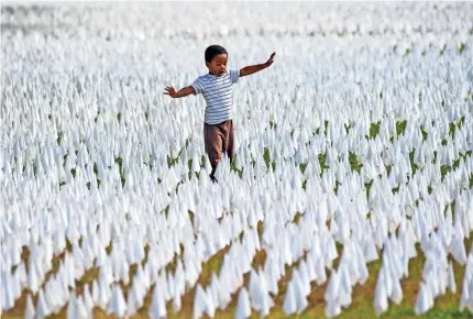  ?? JACK GRUBER/USA TODAY ?? Walter Larkin walks amid an artist’s installati­on in Washington, D.C., in October honoring the nearly 240,000 people who have died from COVID-19. Like in the spring, a winter surge could overwhelm many U.S. hospitals.