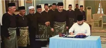  ?? [Foto ihsan Royal Press Office] ?? Tunku Ismail menandatan­gani surat lantikan sebagai Pemangku Raja Johor di Istana Pasir Pelangi, Johor Bahru, semalam.