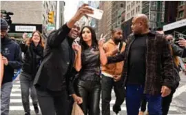  ?? © getty ?? Kanye West (oranje jas) en Kim Kardashian worden belaagd door fans.