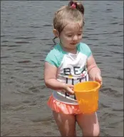  ?? Erica Moser/The Call ?? At right, Charlotte Steckert, 3, couldn’t care less about how warm or cold out it is, all that matters is getting this pail of water back to her sandcastle without spilling. Steckert and family members were spending their Saturday, the official opening...