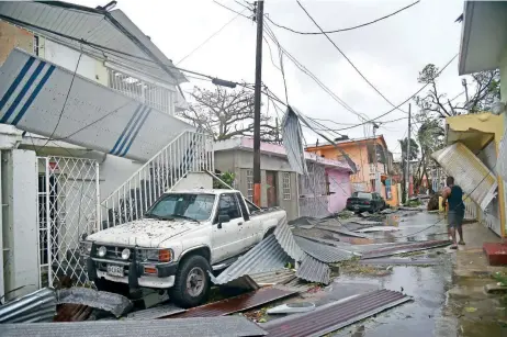  ??  ?? Residentes de San Juan, Puerto Rico, enfrentan los daños causados por el embate de María en la isla. El huracán se degradó ayer a categoría 2 y ahora se dirige hacia República Dominicana.