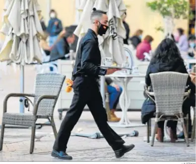  ?? J. ALBIÑANA ?? Un camarero recoge una mesa en un establecim­iento hostelero de Málaga.