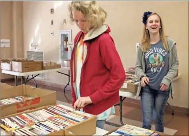  ??  ?? ABOVE: Hayden Weber, 13, and Anna Rose Reid, 13, get a sneak peek at the Friends of the Library Paperback Book Sale on Tuesday morning.
LEFT: Laurissa Platt, 11, and Shelley Reid look over some fiction paperback books.
BELOW: The Friends of the...