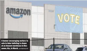  ?? JAY REEVES/AP ?? A banner encouragin­g workers to vote in labor balloting is shown at an Amazon warehouse in Bessemer, Ala., in March.