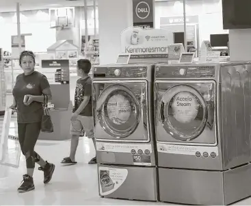  ?? Scott Olson / Getty Images ?? Customers make their way through the appliance department on Thursday at a Sears in Schaumburg, Ill. Neil Saunders of GlobalData Retail says the deal with Amazon is a win for Sears.