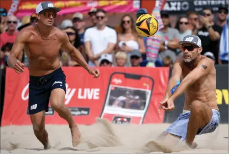  ?? PHOTO BY AXEL KOESTER ?? Phil Dalhausser, right, sets the ball for partner Avery Drost during Saturday’s win against Miles Evans and Chase Budinger at the Manhattan Beach Open.