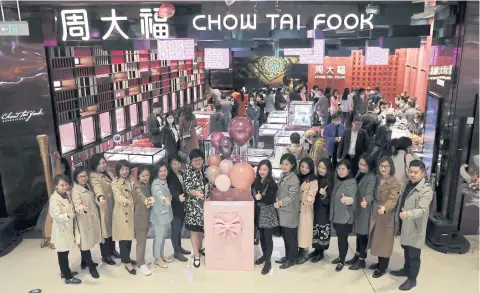  ??  ?? People pose for pictures outside a jewellery store at a new mall in Beijing yesterday. China’s economic recovery quickened sharply in the first quarter.