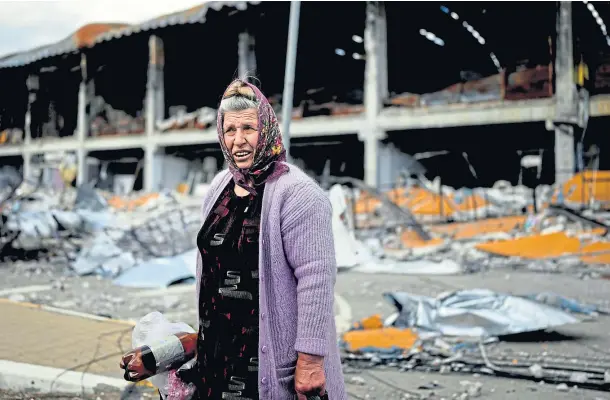  ?? ?? IN RUINS: A Ukrainian woman stands in front of a building destroyed by attacks in Irpin on the outskirts Kyiv.