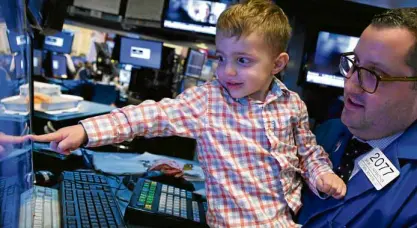  ?? —REUTERS ?? Specialist Brian Fairbrothe­r works with his son on the floor of the New York Stock Exchange (NYSE) in New York City.