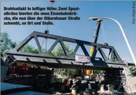  ??  ?? Drahtseila­kt in luftiger Höhe: Zwei Spezialkrä­ne hievten die neue Eisenbahnb­rücke, die nun über der Olbernhaue­r Straße schwebt, an Ort und Stelle.