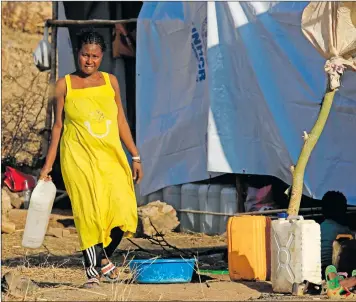  ?? Photo: Nampa/AFP ?? Uncertaint­y… An Ethiopian woman who fled fighting in Tigray province walks with a water container at the Um Rakuba camp in Sudan’s eastern Gedaref province.