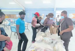  ?? ?? Senior lecturer Sheron Matheson (right) supervises the distributi­on of groceries.
