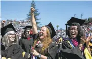  ?? LIPO CHING/STAFF ?? Graduating with a master's in library and informatio­n sciences, Jasmin Avila, right, and Mari Martinez, center, celebrate during their commenceme­nt in San Jose.