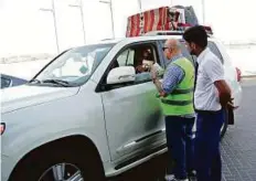  ?? Courtesy: RTA ?? Booklets being distribute­d to travellers under the Accidents Free Summer campaign launched by the RTA.