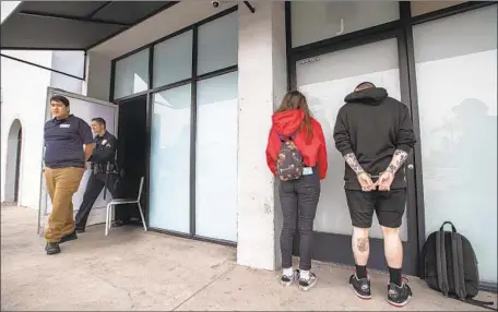  ?? Allen J. Schaben Los Angeles Times ?? L.A. POLICE DETAIN employees of an illegal marijuana dispensary during a raid in May. Such businesses outnumber licensed shops.