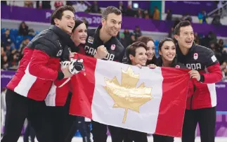  ?? Canadian Press photo ?? The Canadian team poses for a group photo following the Venue Ceremony after winning the gold medal in the figure skating team event in the Gangneung Ice Arena at the 2018 Winter Olympics in Gangneung, South Korea, Monday.