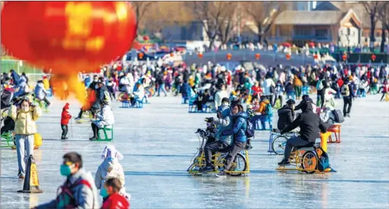  ?? PHOTOS PROVIDED TO CHINA DAILY ?? Tourists play on the ice at Shichahai scenic area, in Beijing, on Dec 31.