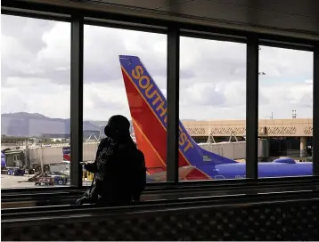  ?? Associated Press ?? ■ A passenger walks past a Southwest Airlines plane March 26 at Sky Harbor Internatio­nal Airport in Phoenix. AT&T and Verizon have agreed to delay the launch of a new slice of 5G service by two weeks after airlines and the nation’s aviation regulator complained about potential interferen­ce with systems on board planes.