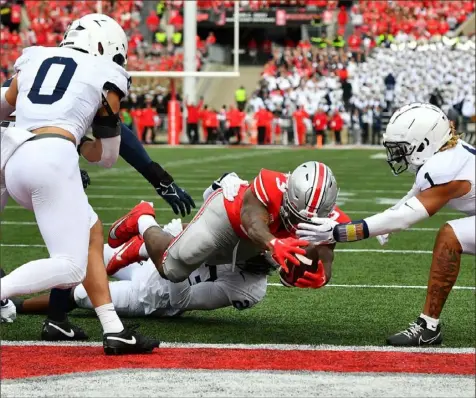  ?? Ben Jackson/Getty Images ?? Ohio State’s Miyan Williams lungest into the end zone to give the Buckeyes a 10-3 lead in the first half Saturday in Columbus, Ohio.