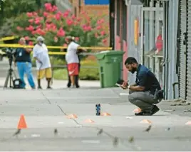  ?? KIM HAIRSTON/BALTIMORE SUN ?? Police investigat­e the scene of a shooting along West North Avenue in West Baltimore. The sprawling crime scene extended two blocks between North Longwood and North Ellamont streets.