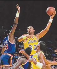  ?? Rick Stewart/Allsport/Getty Images ?? Kareem Abdul-Jabbar (33), center for the Los Angeles Lakers jumps to make a layup basket over Patrick Ewing (33) of the New York Knicks during their game on Jan. 22, 1988 at the Great Western Forum arena in Inglewood, Calif. Abdul-Jabbar’s reign atop the NBA career scoring list is about to end after nearly four decades. LeBron James is on the verge of passing Abdul-Jabbar for the record that he’s held since 1984.