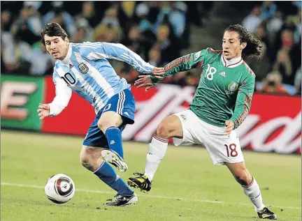  ?? Picture: ANTONIO MUCHAVE ?? ARTFUL DODGER: Argentina’s Lionel Messi dribbles around Mexico’s Andre Guardado during their World Cup match last night